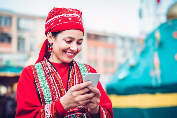 A young woman relaxing with her phone while dynamic casino elements float around her, illustrating the smooth mobile experience offered by the RAJ123 app.